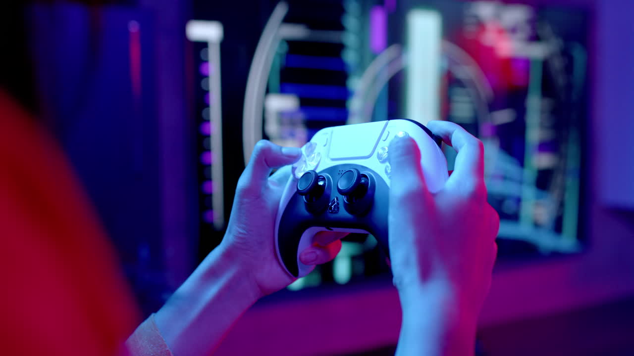 Playing video game, person holding controller and focusing on screen in dark room
