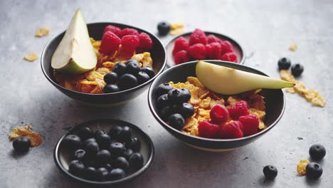 Goldene-Cornflakes-Mit-Frischen-Früchten-Von-Himbeeren,-Blaubeeren-Und-Birne-In-Keramikschale