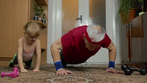 Kind,-Mädchen-Mit-älterem-Großvater-In-Sportkleidung,-Der-Zu-Hause-Sportübungen-Mit-Liegestützen-Macht