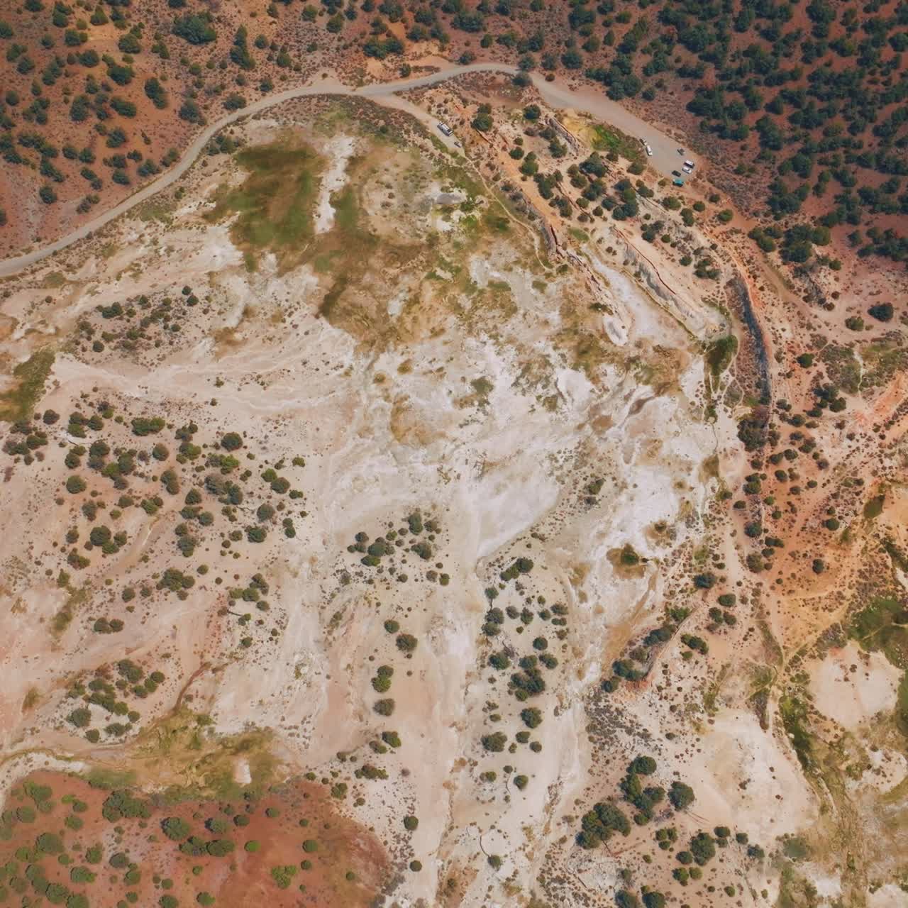 Travertine Hot Springs scenery at daytime. Highway with few cars parked at the end of the road. Aerial perspective