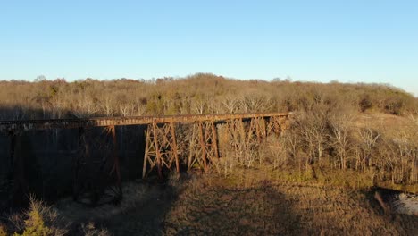 aerial shot pushing in towards the pope lick railroad trestle in louisville kentucky at sunset