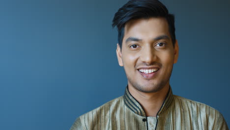 close-up view of indian young man in traditional clothes smiling at camera