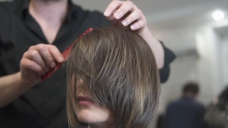 peluquero profesional usando cepillo después del corte de pelo