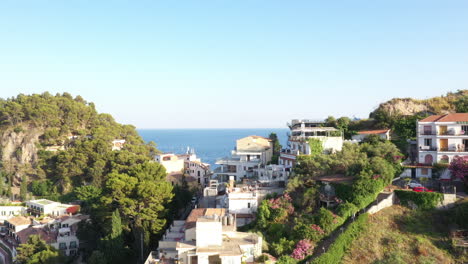 aerial drone view revealing two neighboring hills with mediterranean sea in the background