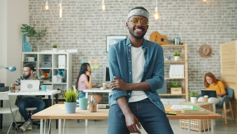 portrait of creative african american guy in funny glasses smiling in office