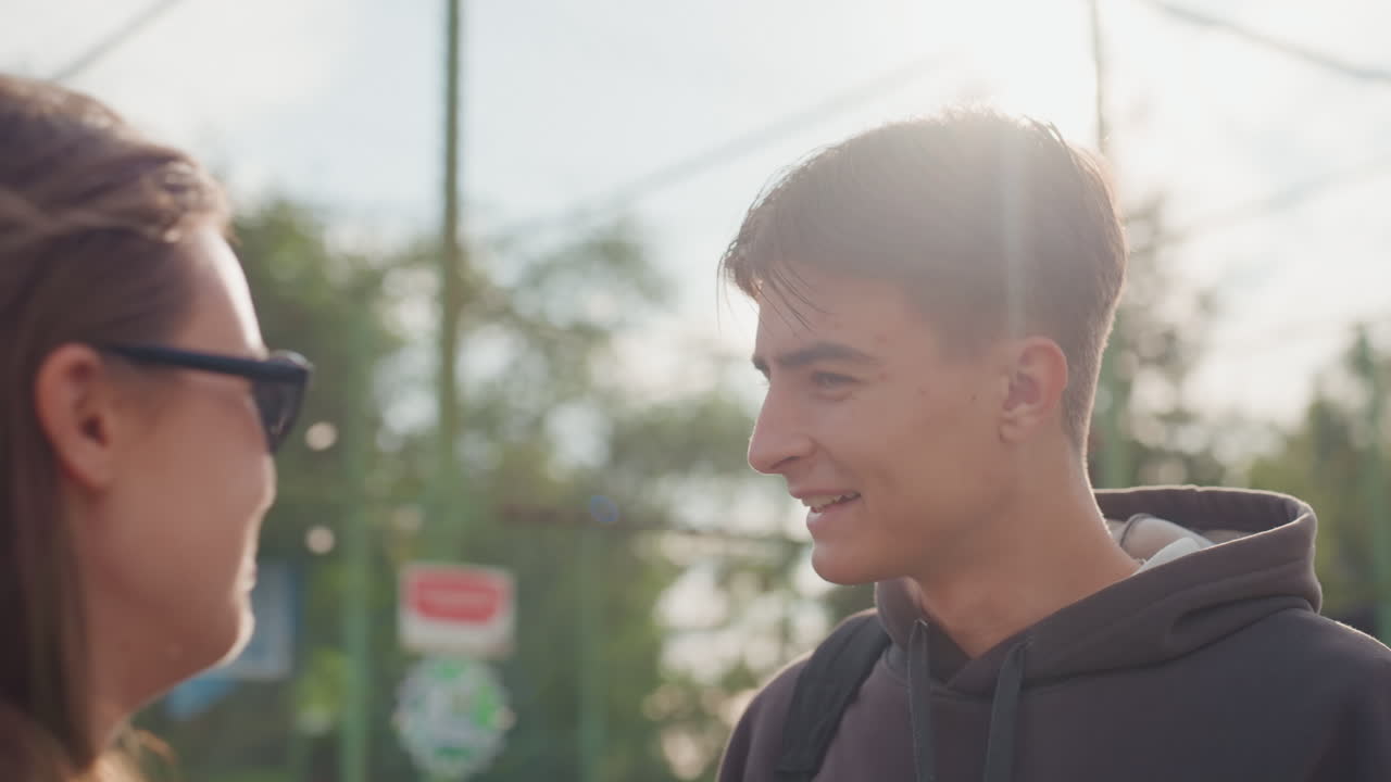 adolescente caucásico con sudadera con capucha en una cancha deportiva que se refleja, estudiante pensativo hace una pausa en un momento de tranquilidad y luego intercambia palabras tensas pero sinceras con un amigo, luz de fondo suave y cerca suburbana, primerísimos primeros planos de retrato sincero