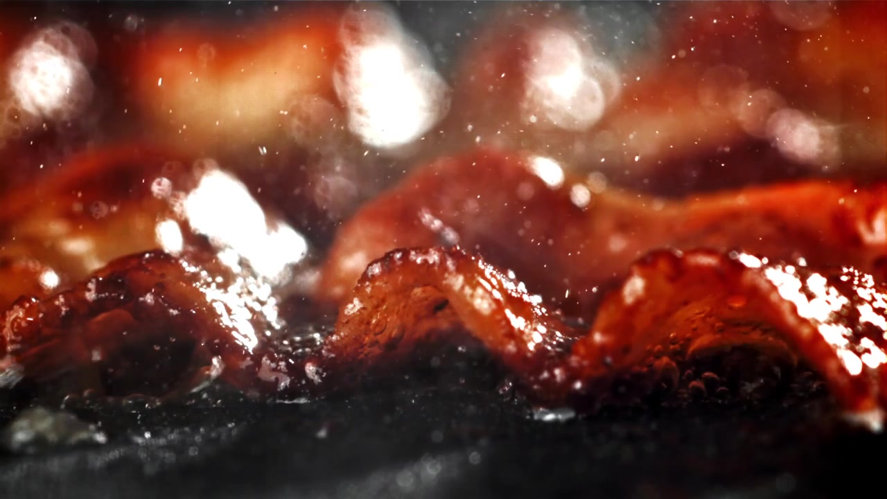 Deilig bacon som freser og bobler i varm olje
