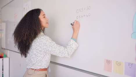 maestra, escritura y tablero de matemáticas