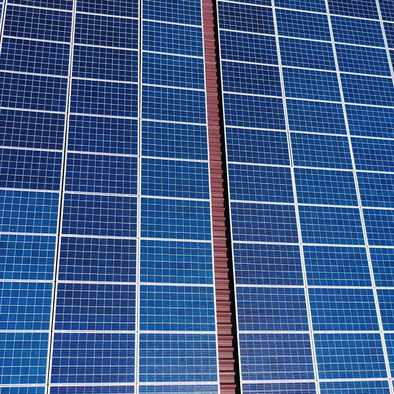 Solar panels on red roof. Aerial movement over a house roof with solar panels on top. Close-up.