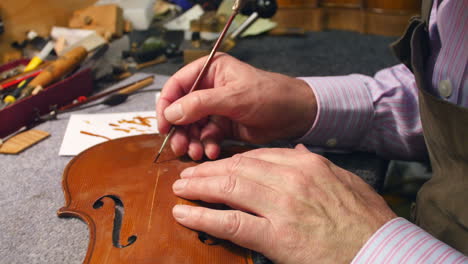 hombre restaurando el violín en el taller