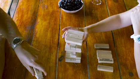 people playing jenga on a wooden table