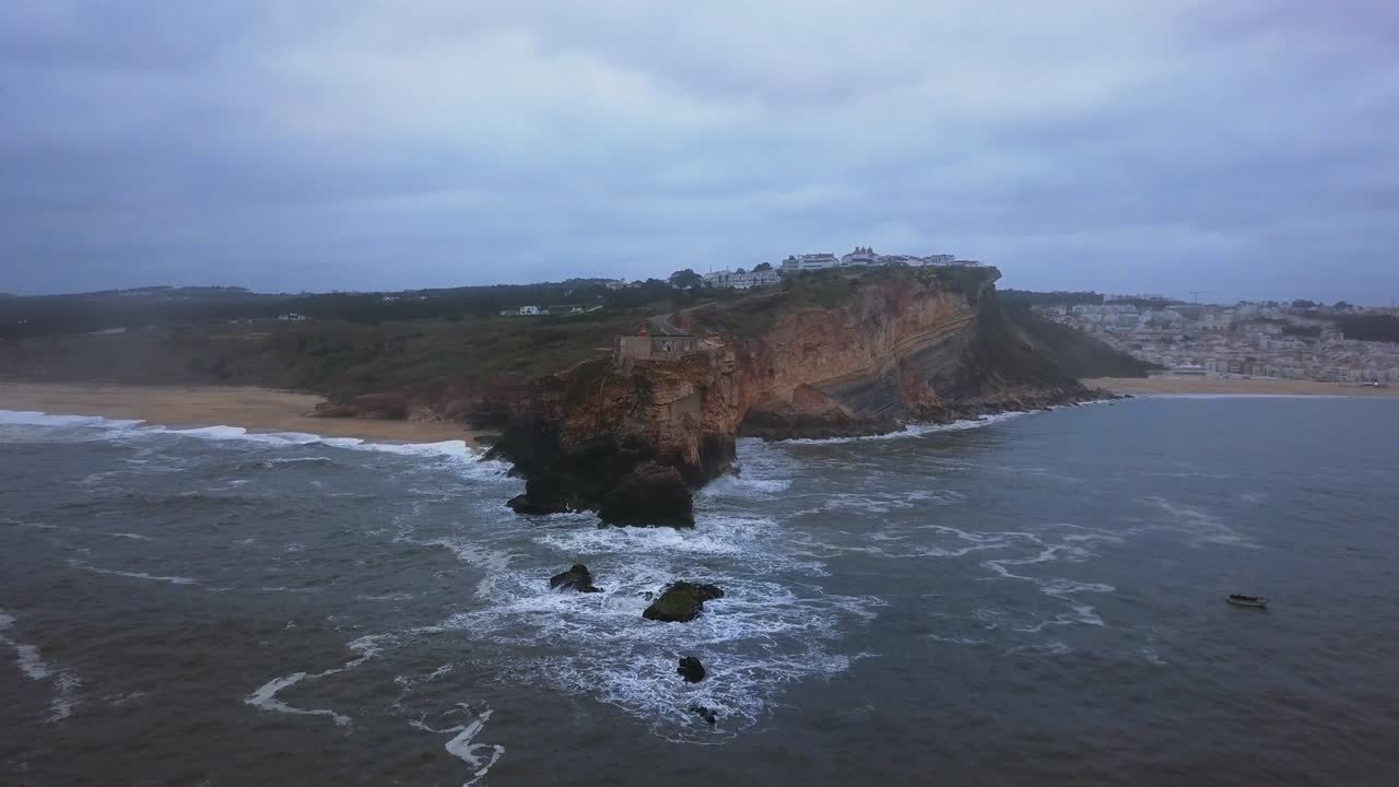 An iconic place on the Atlantic coast, the Mecca of big-wave surfing. View of Nazare's lighthouse in Zon North Canyon, place with the biggest waves in Europe, Nazare, Portugal