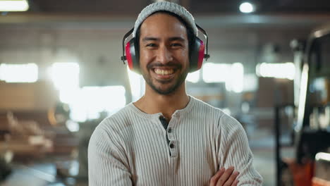 smiling woodworker wearing ear protection in workshop