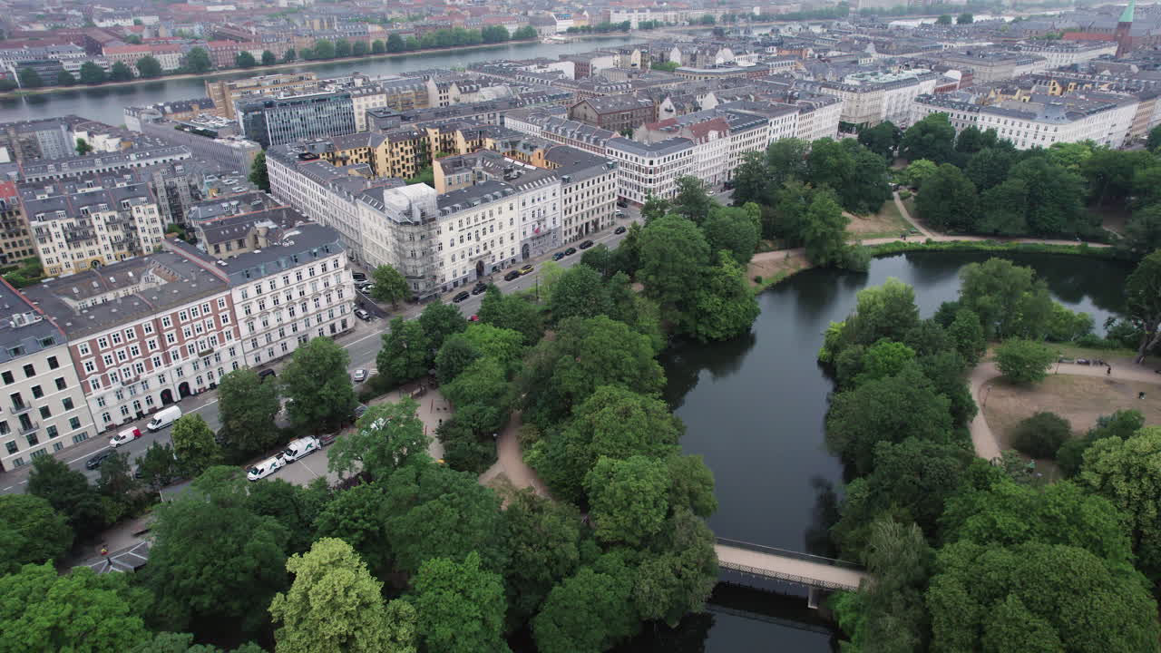 Gazing from above, one can appreciate &Oslash;rstedsparken's verdant trees and tranquil lakes, harmoniously blending with the surrounding cityscape of central Copenhagen