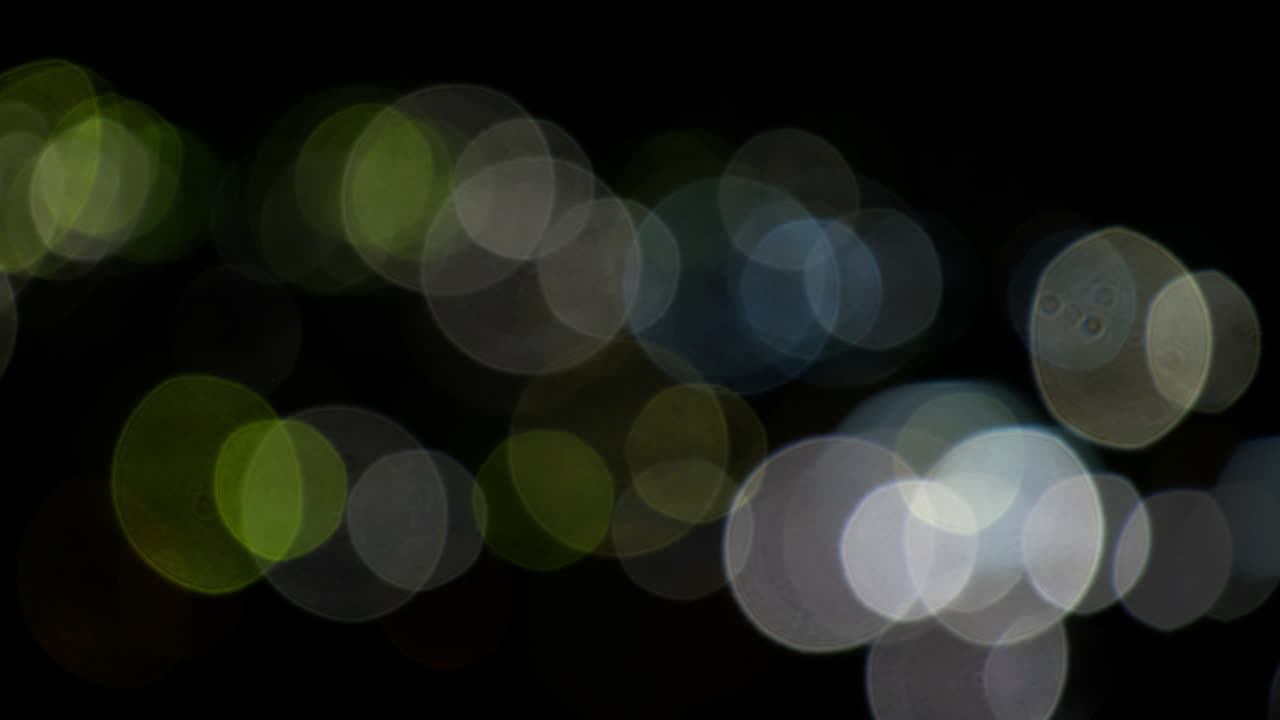 fondo de video bokeh de círculos de luz en negro. efecto de fugas de luz de la lente