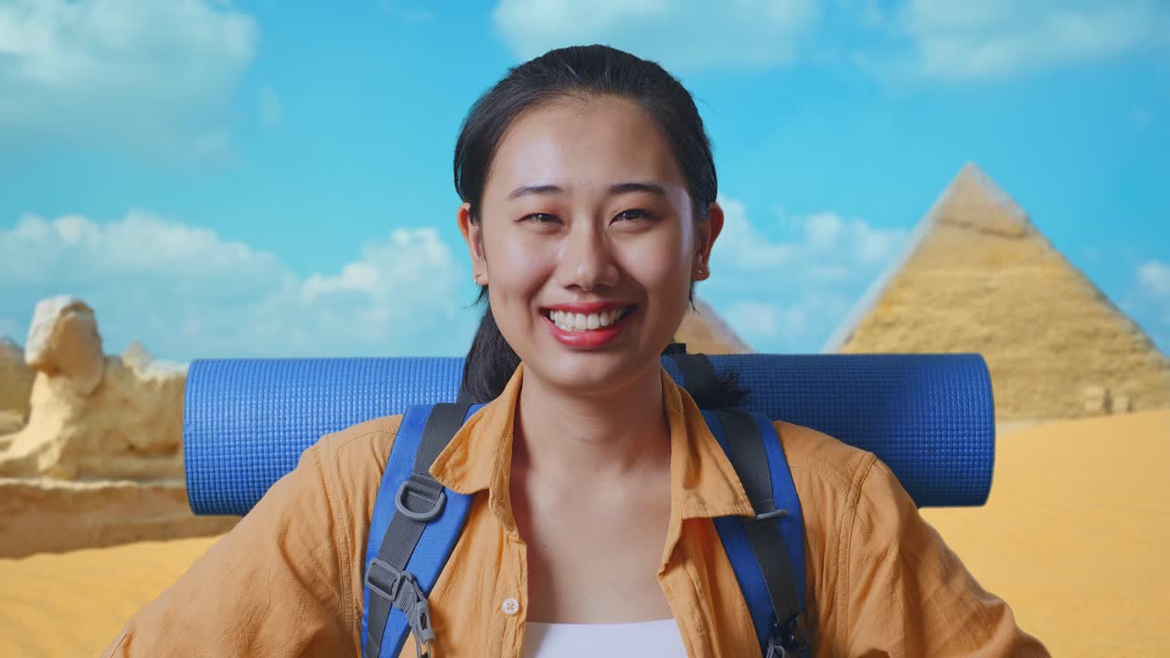 Close Up Of Asian Female Hiker With Mountaineering Backpack Smiling And Posing Arms Akimbo While Traveling In Pyramid Of Giza