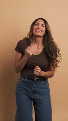 happy adult hispanic woman dancing and smiling. vertical footage