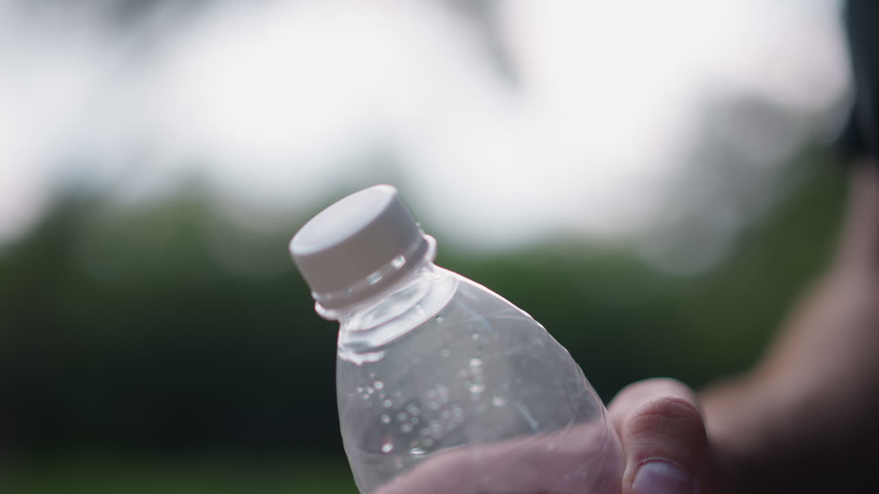Water Hand Press, Closeup Of Hand Pressing Water From Bottle In Outdoor Environment, Detailed Image Capturing Male Hand Applying Pressure To Extract Water Outdoors From Plastic Bottle