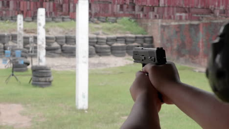 slow motion scenes of the gun firing at a shooting range on the man hand withhold the gun tight and pull the trigger