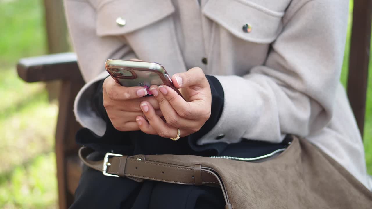 야외에서 스마트폰을 사용하는 여성