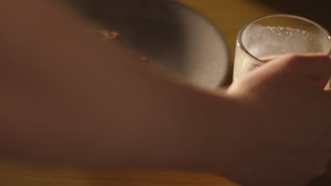브라우니의 접시 의 테이블에 뜨거운 초콜릿 음료의 증기 컵을 내려 놓는 사람의 근접