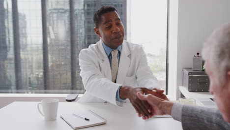 Senior-Couple-Arriving-For-Hospital-Consultation-With-Male-Doctor-Shaking-Hands