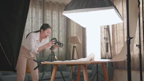 asian female photographer celebrating succeed taking photos of women's shoes in home studio