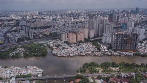 Ho-Chi-Minh-City,-Vietnam-aerial-hyperlapse-during-day-time-with-dramatic-highlights-and-shadows-with-boats-on-canal-and-road-traffic-over-bridge-showing-old-and-new-architecture