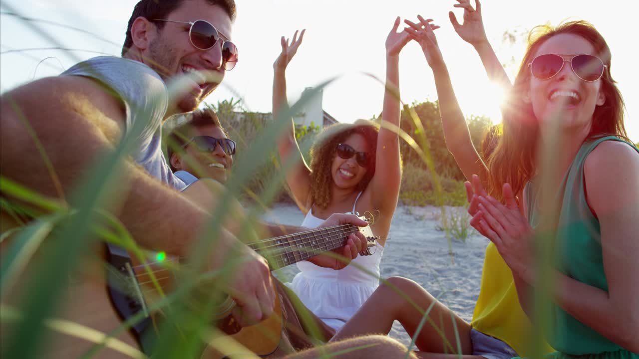 amigos multiétnicos relajándose y tocando la guitarra