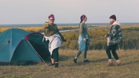 las chicas tienen una fiesta en el campamento turístico en la orilla del río cámara lenta