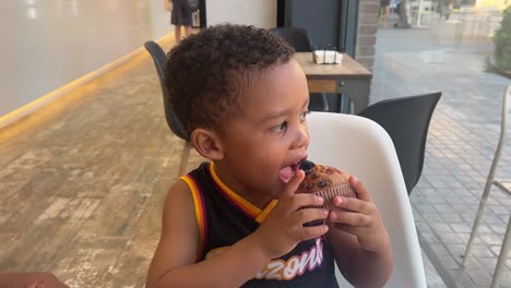 multiracial boy eating muffin, portrait