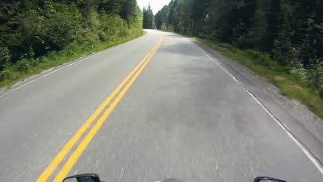 Clip-Pov-De-Un-Motociclista-En-Un-Sinuoso-Camino-Forestal-De-Montaña-En-El-Verano