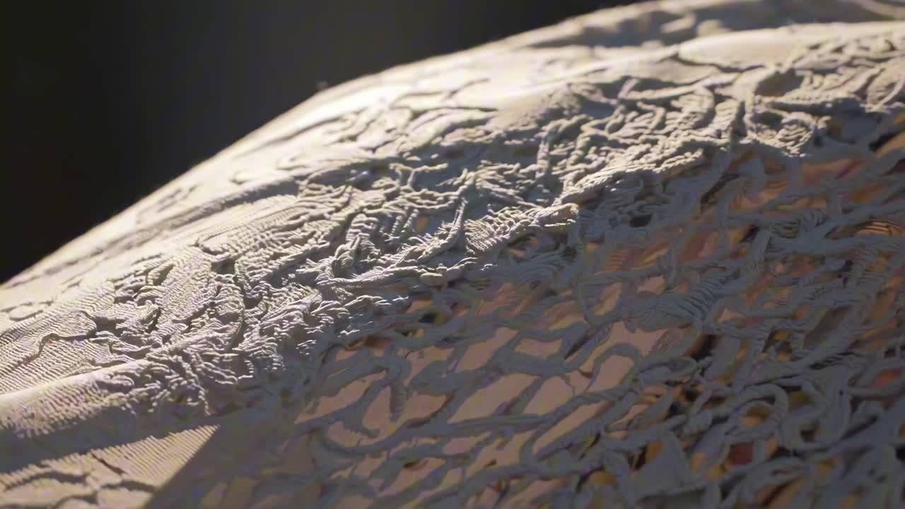 Close-up video shot of intricate lace fabric in warm lighting, showcasing detailed textures