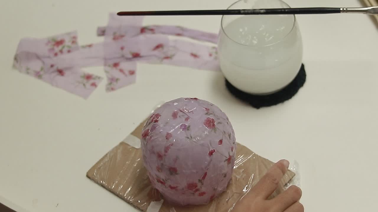 Showing a finished craft project using cornstarch glue and recycled fabric to create a decoupage container