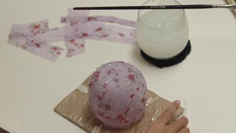 showing a finished craft project using cornstarch glue and recycled fabric to create a decoupage container