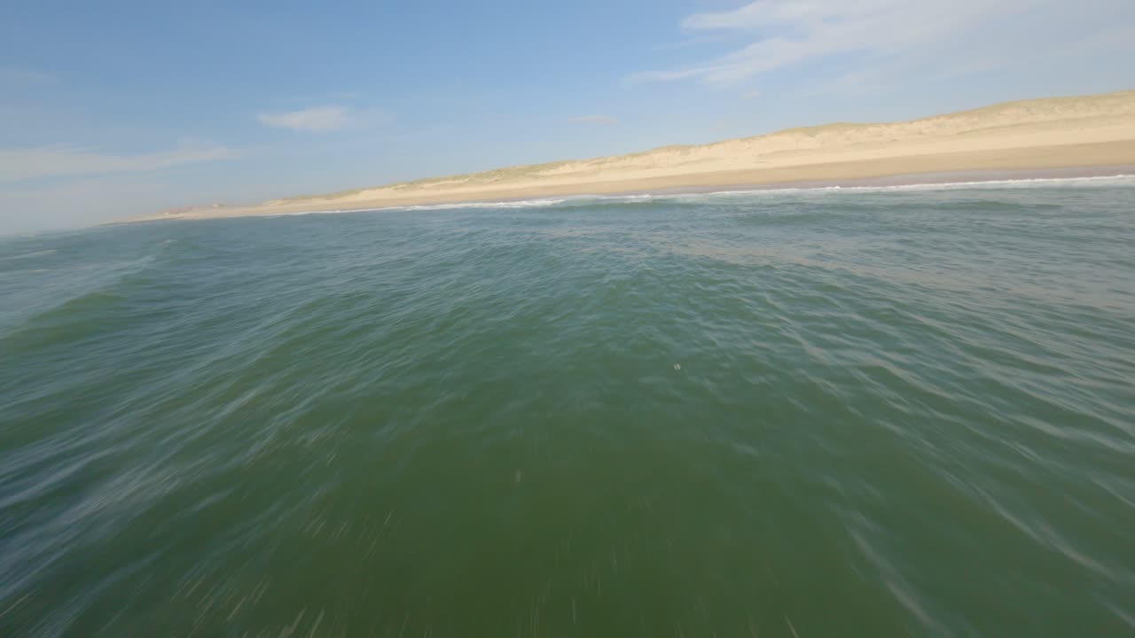 drone aéreo fpv volando sobre las olas del océano rompiendo en la playa, soustons en francia