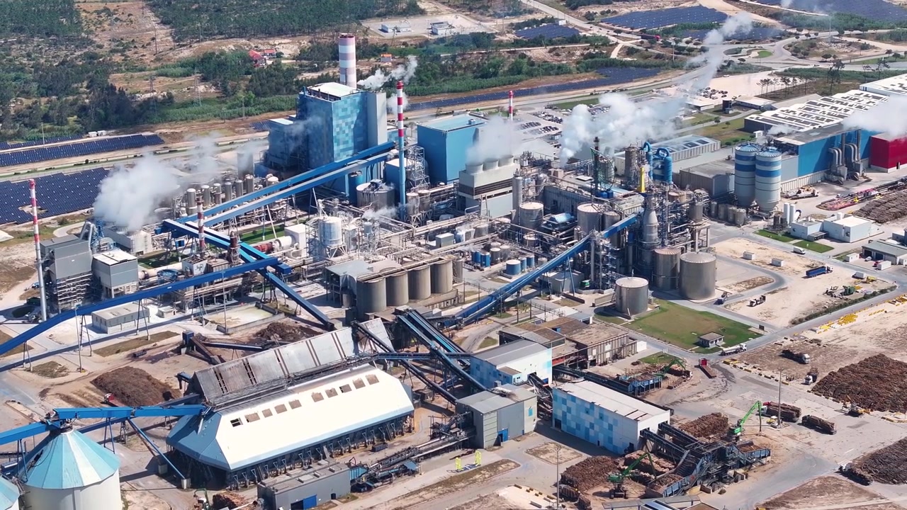 Industrial pulp and paper mill producing cellulose from wood. Aerial view of the factory complex with biomass power plant and smokestacks