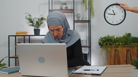 Mujer-De-Negocios-Trabajando-En-Una-Computadora-Portátil-En-La-Oficina-Con-Ansiedad-Comprobando-El-Tiempo-En-El-Reloj-Retrasado,-Fecha-Límite