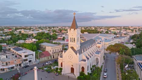 aerial establishing shot of cathedral san pedro apostol during golden sunset on dominican republic - rising drone shot