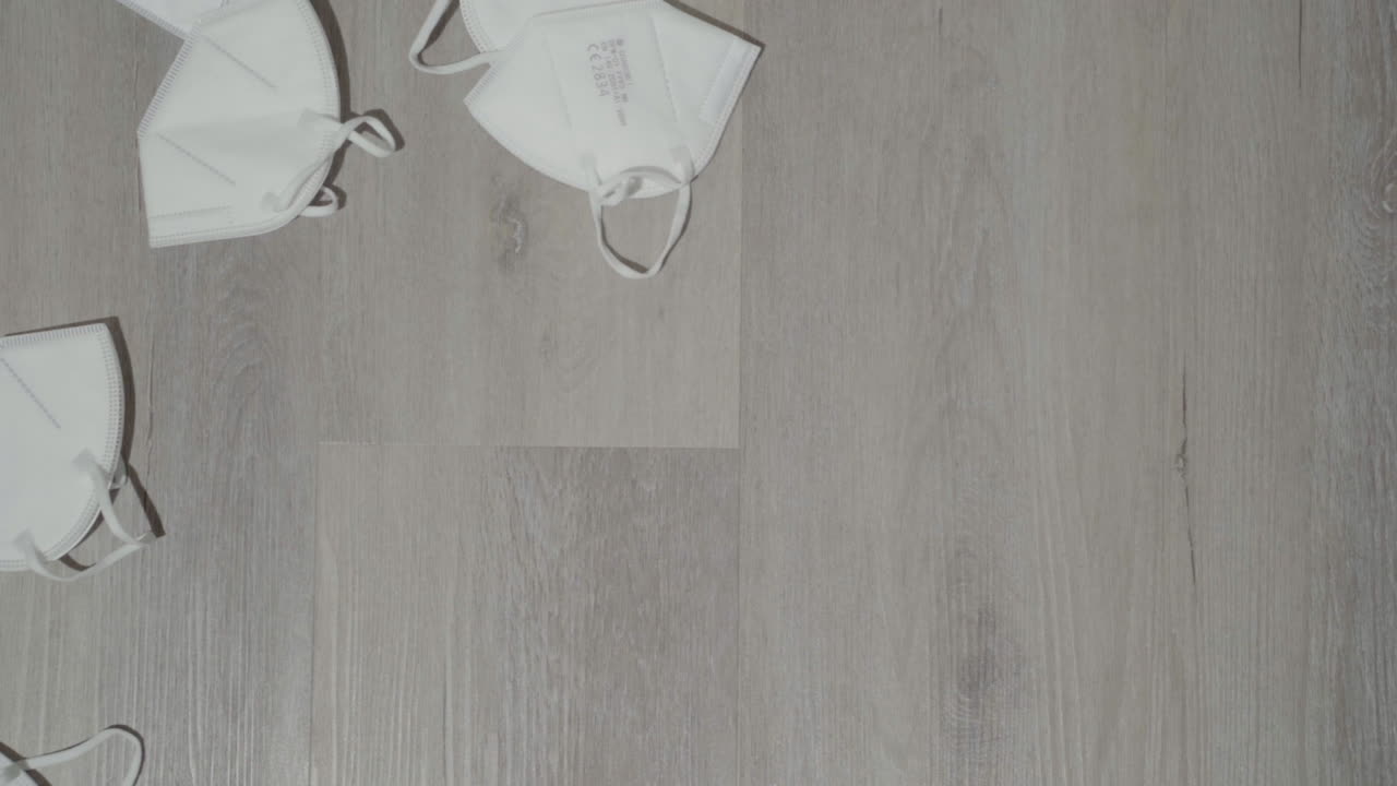 나무 표면에 천천히 떨어지는 kn95 흰색 얼굴 마스크