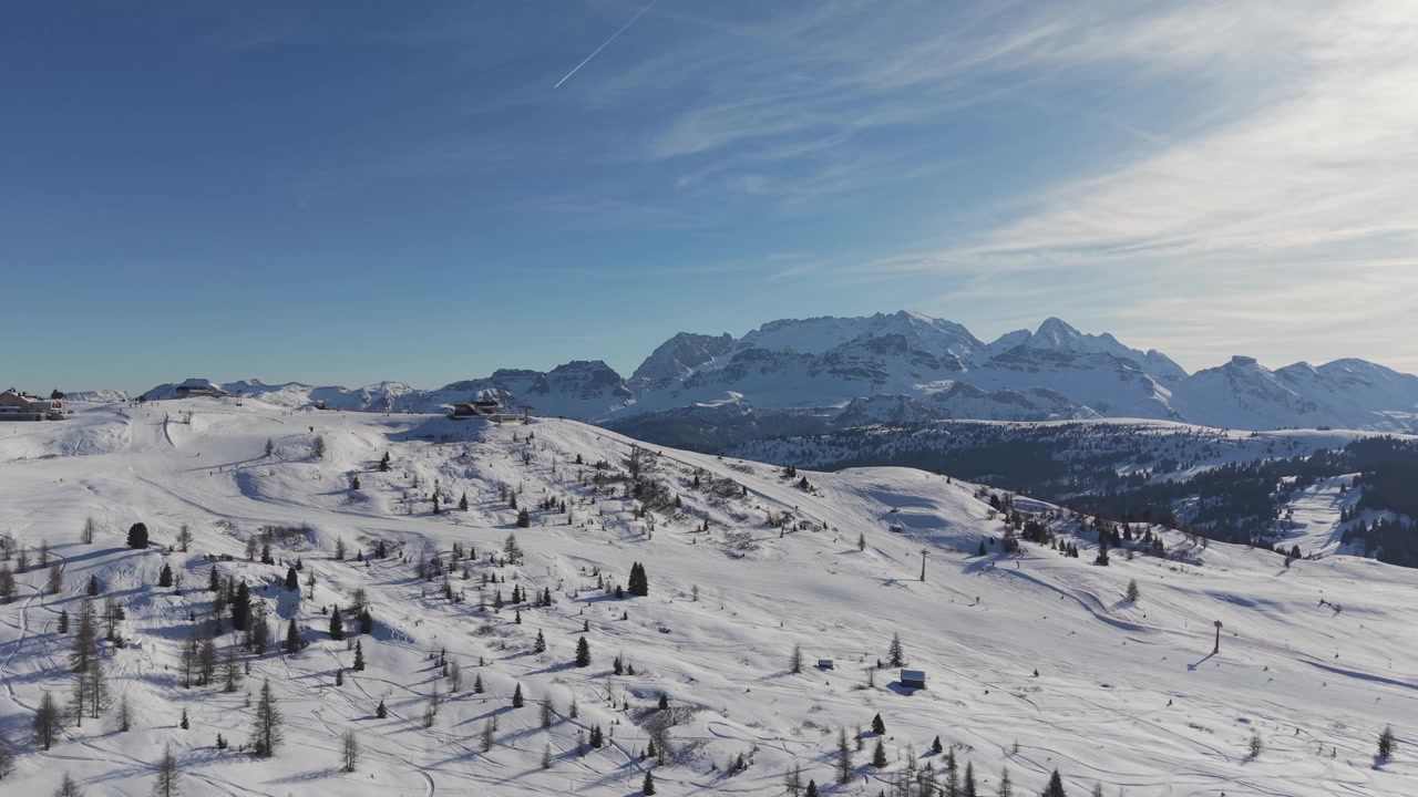 Ampia vista invernale attraverso l'altopiano sciistico del Piz Sorega a San Cassiano, Alta Badia, con il Gruppo del Sella che domina il paesaggio innevato delle Dolomiti.