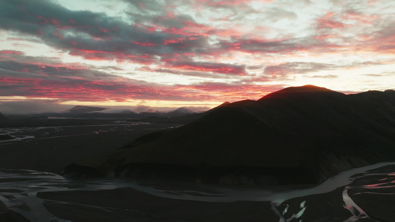 Slow aerial rise over peak during brilliant sunrise, Landmannalaugar, Iceland