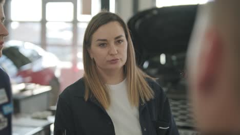 female manager discussing vehicle repair with mechanic in auto repair shop