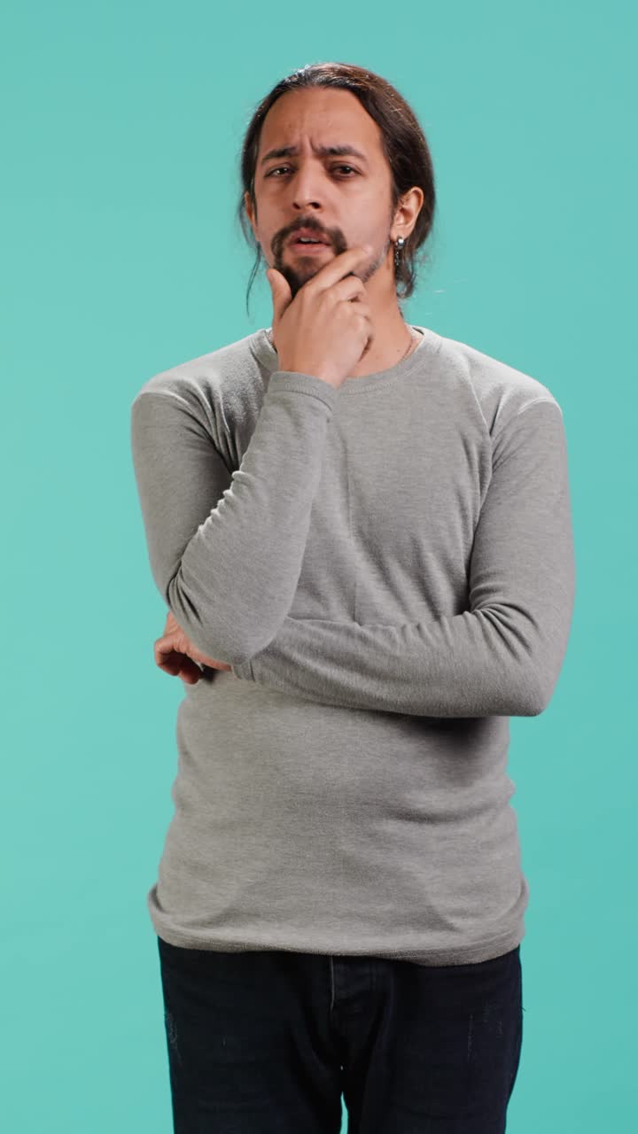 Vertical video Unsure person doing stroking chin gesture, thinking
