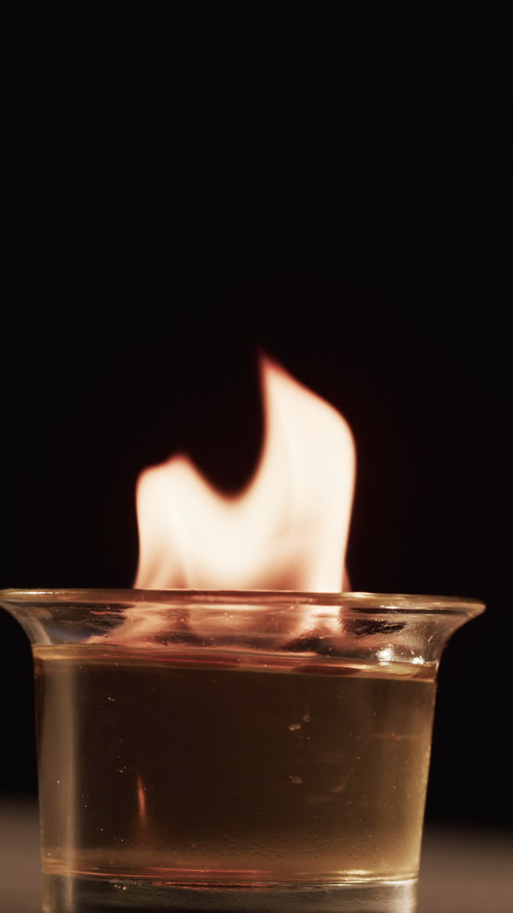 Video verticale di fiamme di alcol accese e spazio per il testo su sfondo nero