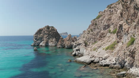 Slow-Aerial-Flight-over-Turquoise-Blue-Ocean-with-Rocky-Cliff-Coast