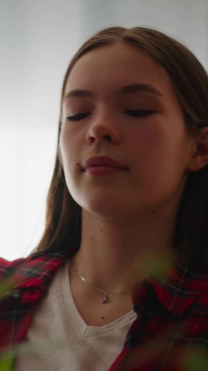hermosa mujer alegre pulveriza hojas de una gran planta de interior en casa en cámara lenta. planta exótica en maceta refrescante. cuidado y cultivo del jardín doméstico