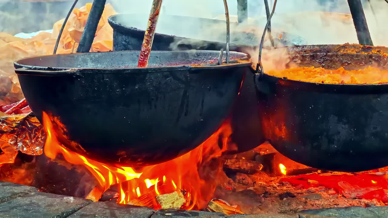 Des chaudrons de nourriture mijotent sur un feu ouvert dans la cuisine extérieure du marché de Noël de Riga