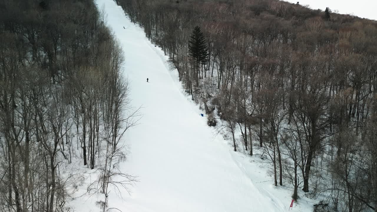 The aerial footage features a snowboarder carving down Yabuli resort's slopes with impressive skill and speed
