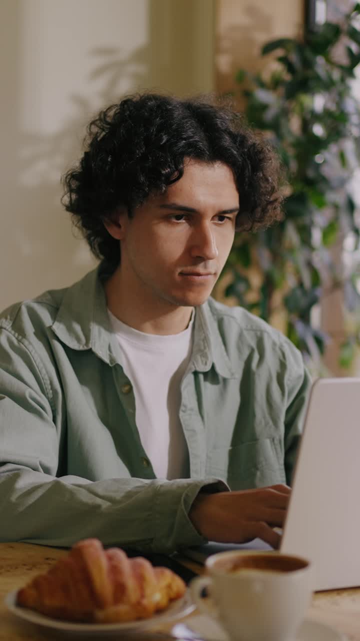 Giovane uomo concentrato mentre digita al portatile